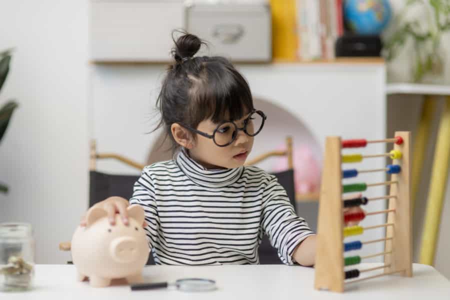 Asian child playing with piggy bank for payment solution